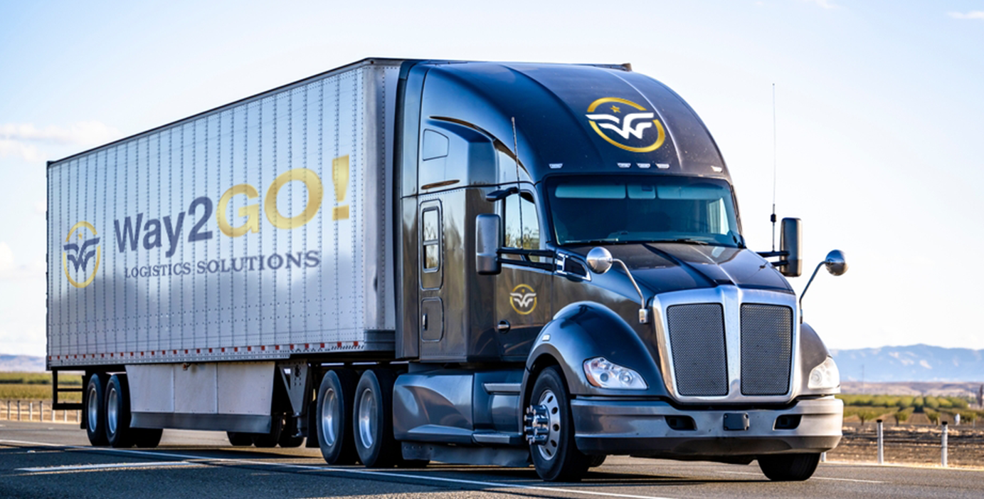 Navy blue Kenworth truck with Way2GO! Logistics Solutions branding on silver trailer